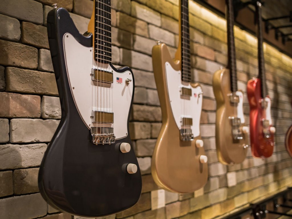 Harmony Silhouette and Juno Electric Guitars hanging in a music store